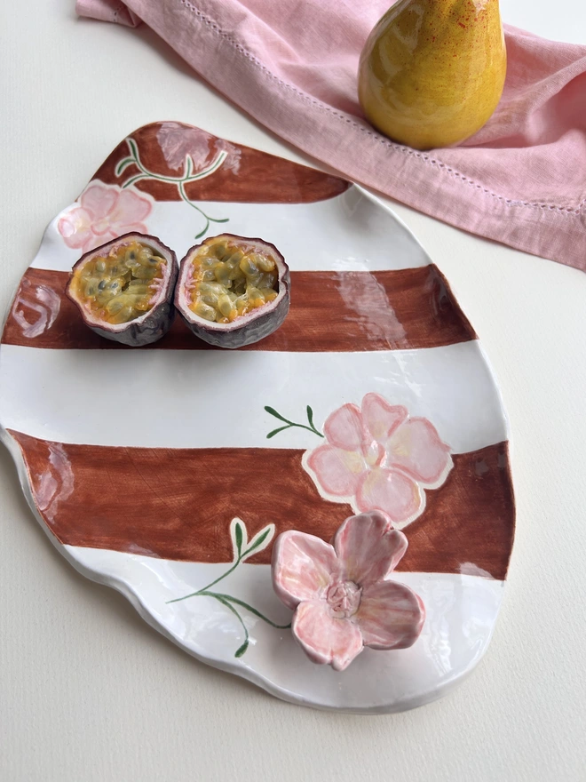 Brown and white striped wavy edged platter with a pink 3d flower