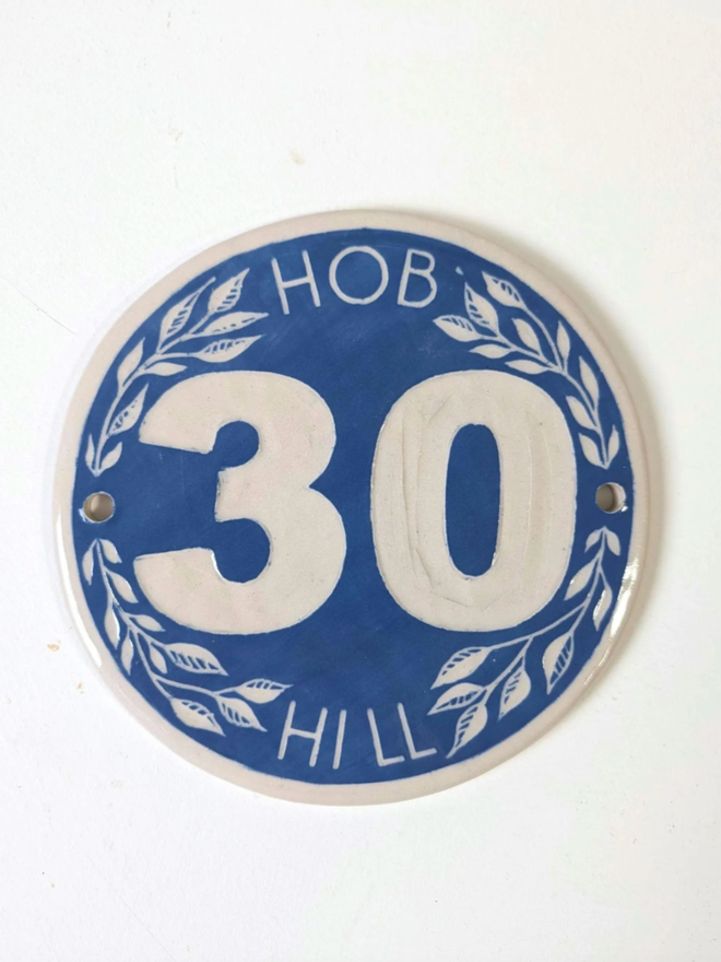 Handmade Stoneware Leaf House Number Sign. A sign in blue.