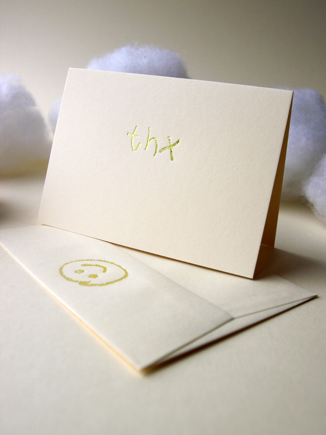 sandy coloured card with thx short for 'thank you' hand foiled in kids hand writing