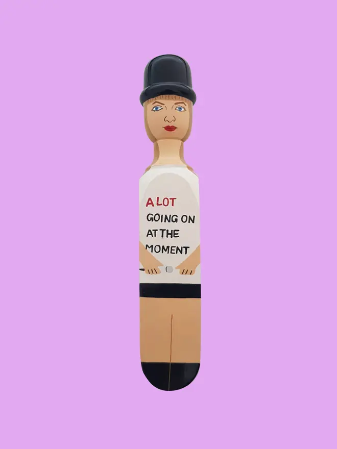 Wooden Door Stopper (Swifty Going On Outfit), a colourful wooden door stop sitting on a pink background
