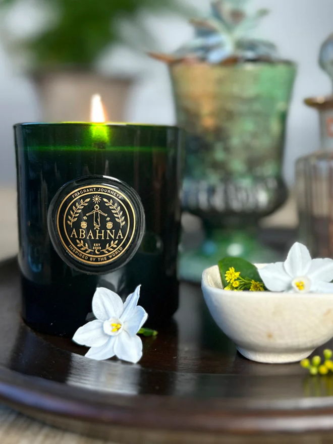 mandarin and sicilian bergamot natural wax candle. a green glass container candle burning.