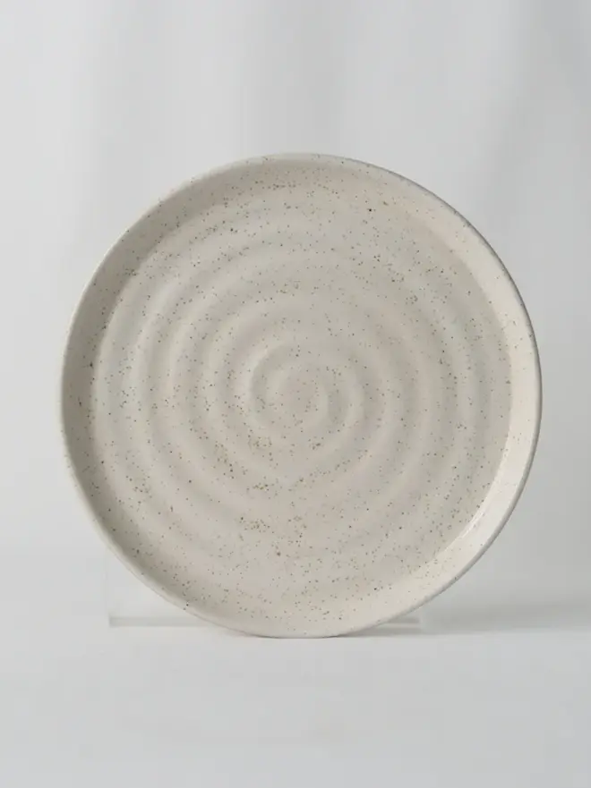 white speckled ceramic cake plate with textured swirl design