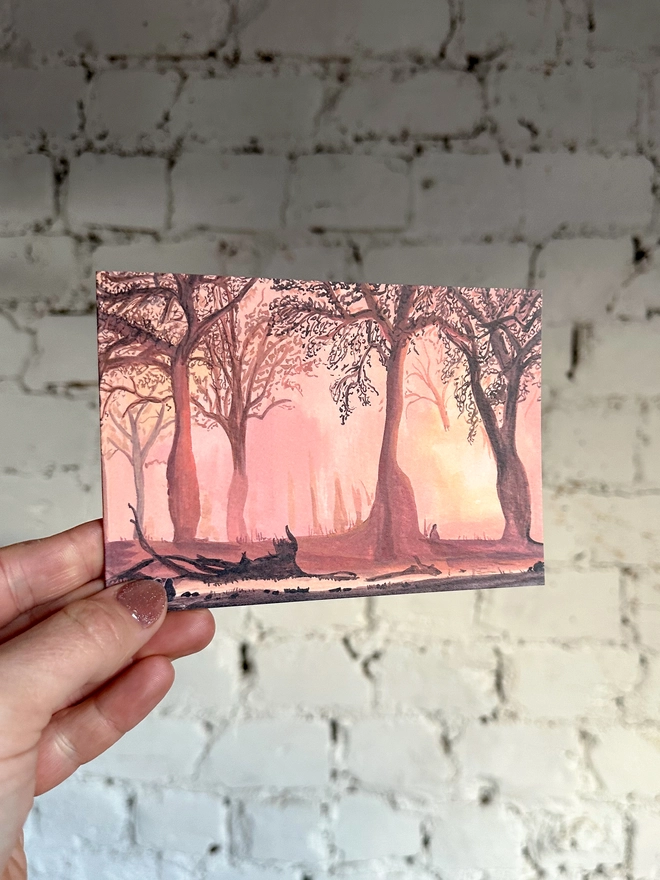 a greetings card featuring an illustration of a landscape of a sunset coming through trees with a few silhouettes of baboons enjoying it too