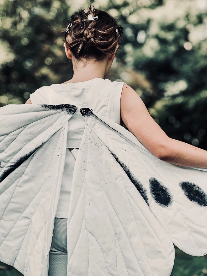 a close up of a girl wearing a black and white Butterfly costume