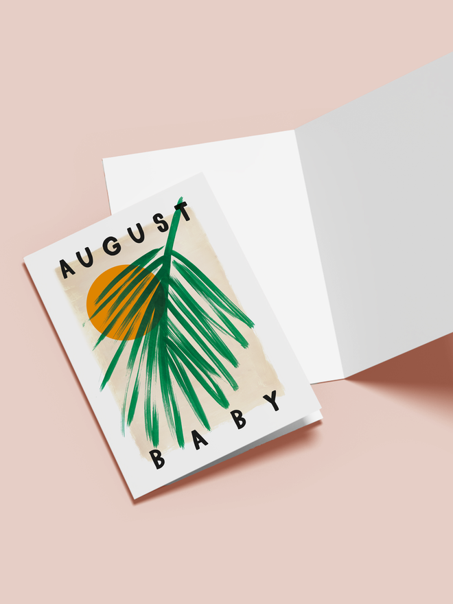 august baby illustrated card. a beige card with a sun and palm leaf.