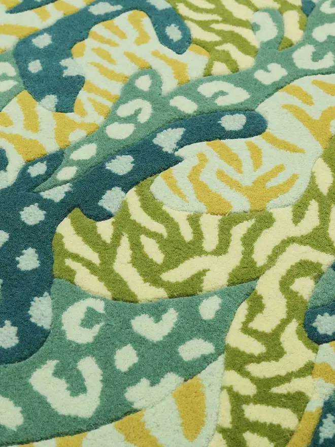 Big Cat Camo Hand Tufted Rug, a colourful rug sitting on a plain surface. 