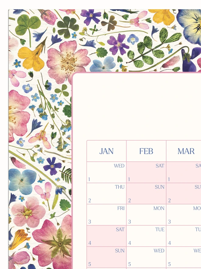 Close-up of a pretty floral year wall planner. A 2025 calendar with a delightful pressed flower design. Perfect for bringing a touch of the outdoors to any studio, home office or workspace. 