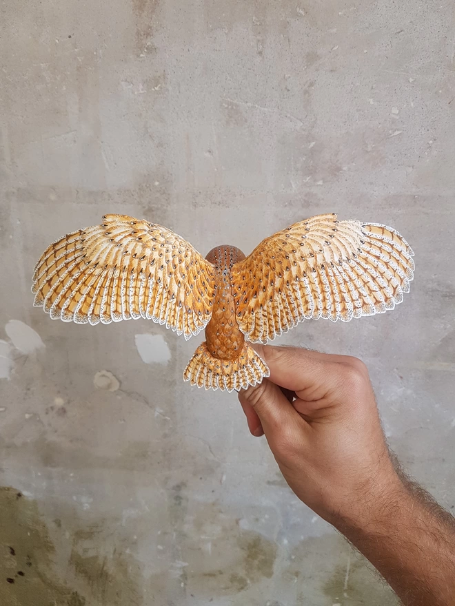Handmade paper barn owl sculpture in hand of artist