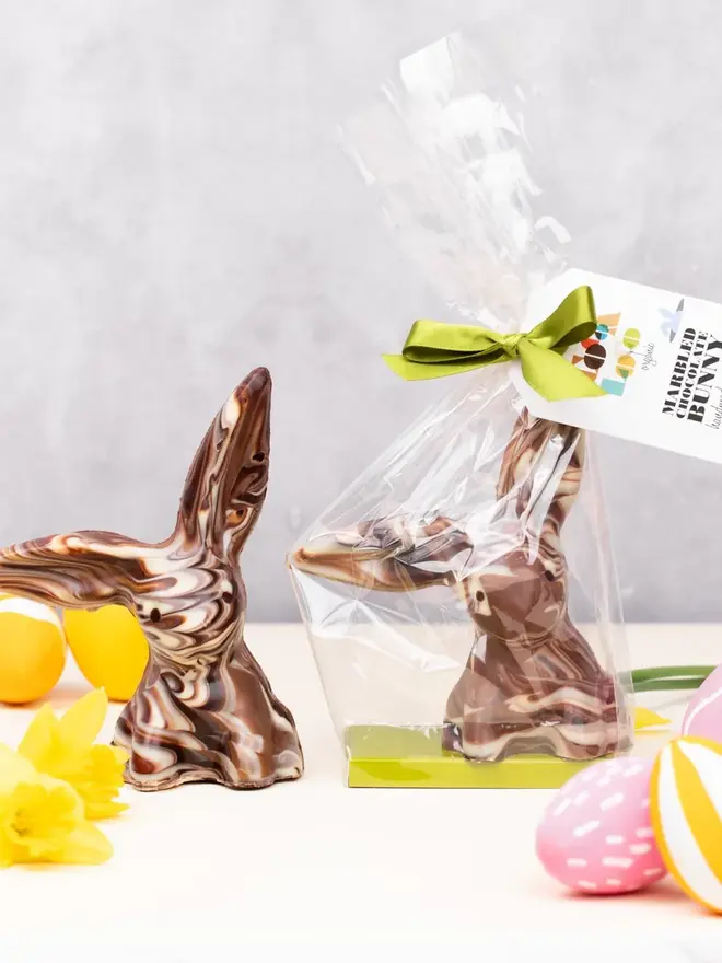 Solid Marbled Chocolate Bunnies one with wrapping on it with easter eggs around them