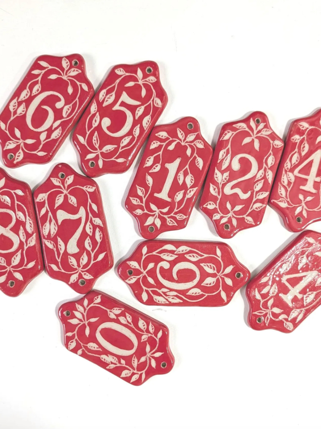 Red Sgraffito Leaf Address Tile. A selection of red tiles.