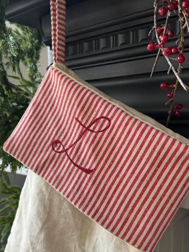 Striped Embroidered Christmas Stocking hanging from a mantle