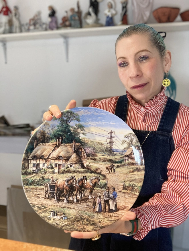The artist Lucy is holding the plate in her hands.