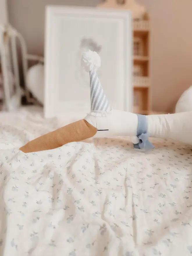 Circus Swan Hanging Decoration, a swan decoration on a bed in a child's room. 