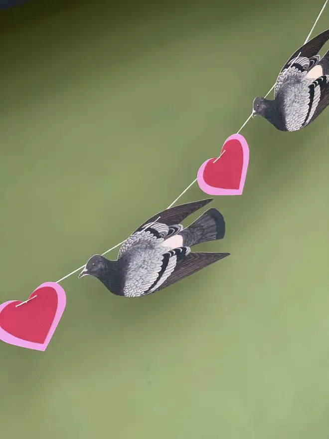 bunting made of hand cut paper pigeons and red hearts