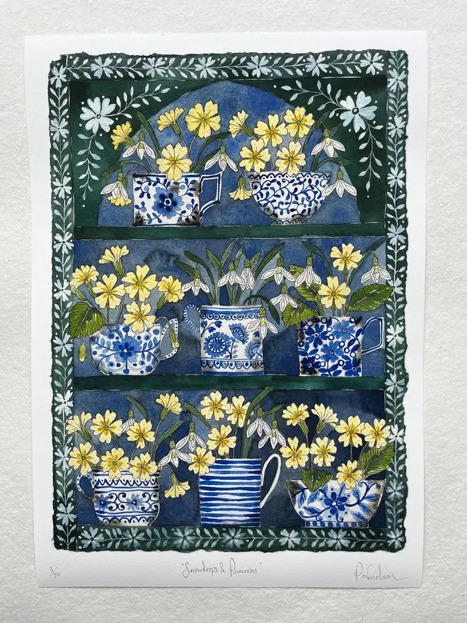 Snowdrops and primroses in delftware, ceramic mugs displayed in a plant Theatre print