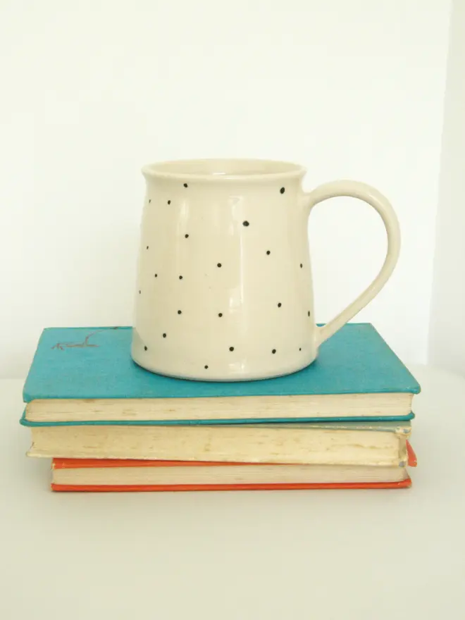large personalised hand-thrown mug. mug photographed from the back, placed on top of a pile of books.