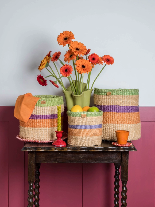 lifestyle showing purple, orange and green stripe woven baskets