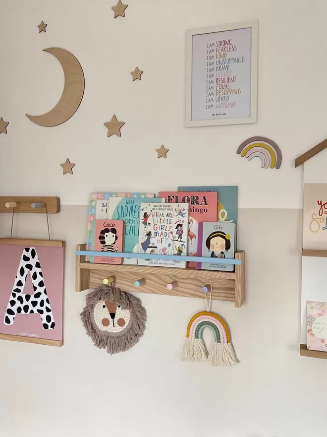 A colourful kids pegrail bookshelf  in a beautiful girls bedroom 