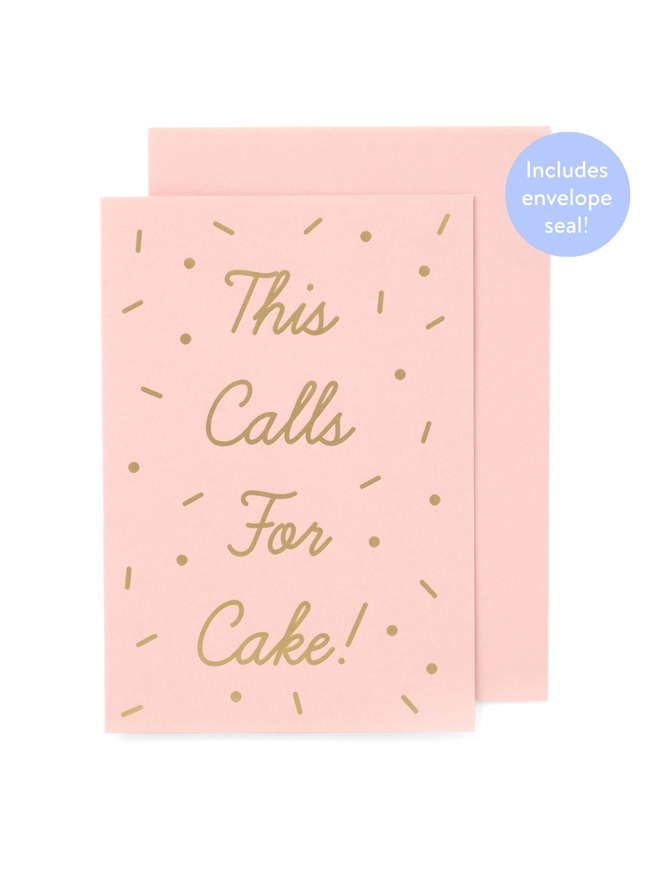 An elegant pink greeting card that says 'This Calls For Cake!', surrounded by Gold Sprinkles, with an envelope that has a seal