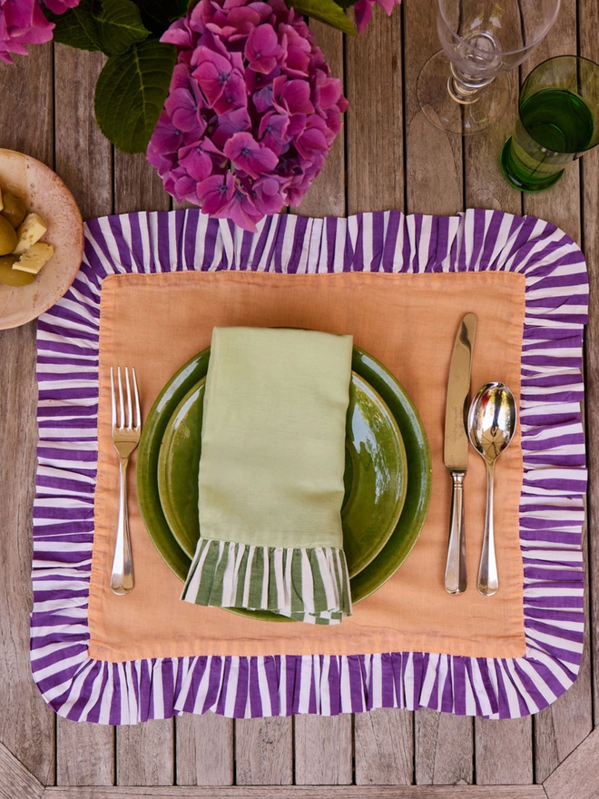 Pair of Ruffle Napkins. A spread out napkin in peach and violet.