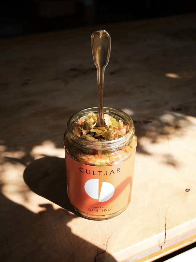 Ferment Intro Journey (Set Of 5), a jar of ferment sitting on a wooden surface in the sunlight. 