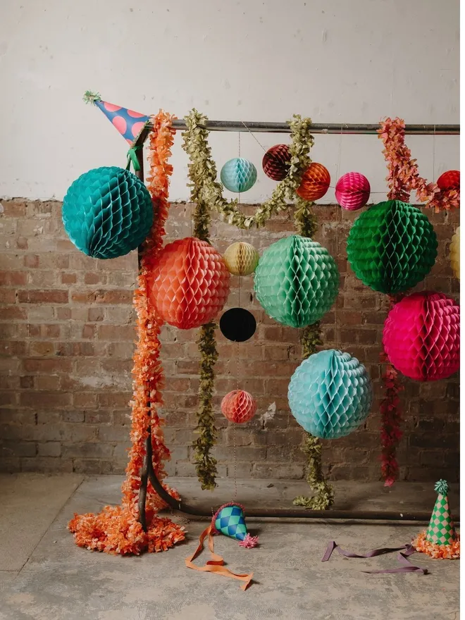 Paper ball decorations hanging on a rail with other fun party decor
