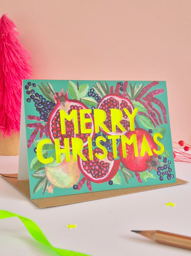 Pomegranate Christmas Card with Merry Christmas Paper cut slogan backed with neon yellow paper 