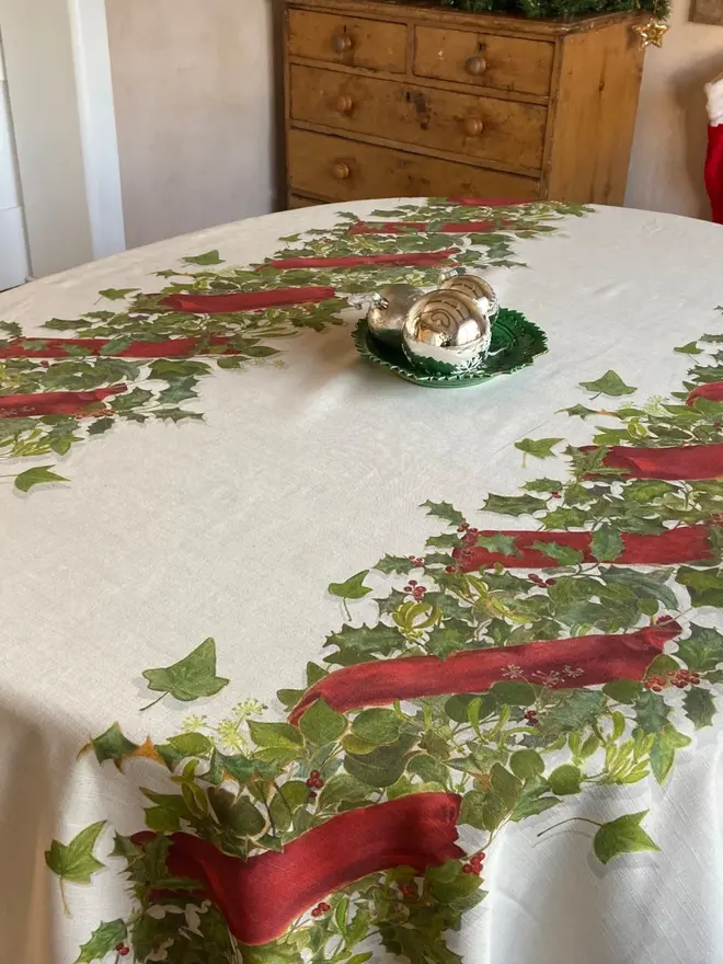 christmas double garland tablecloth. a white table cloth with two painted christmas garlands on a table.