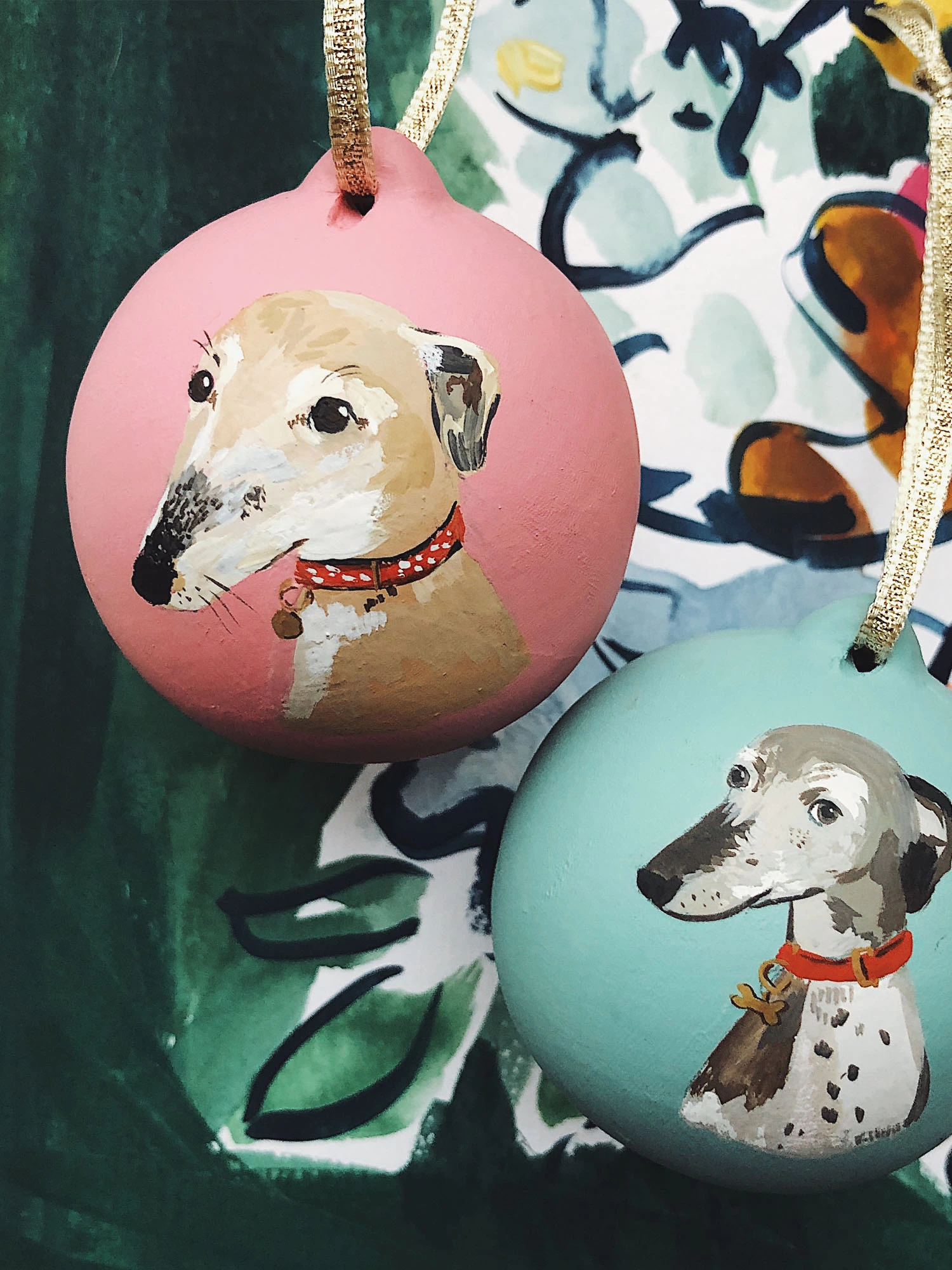 Two christmas baubles featuring painted  illustrations of sight hounds. 