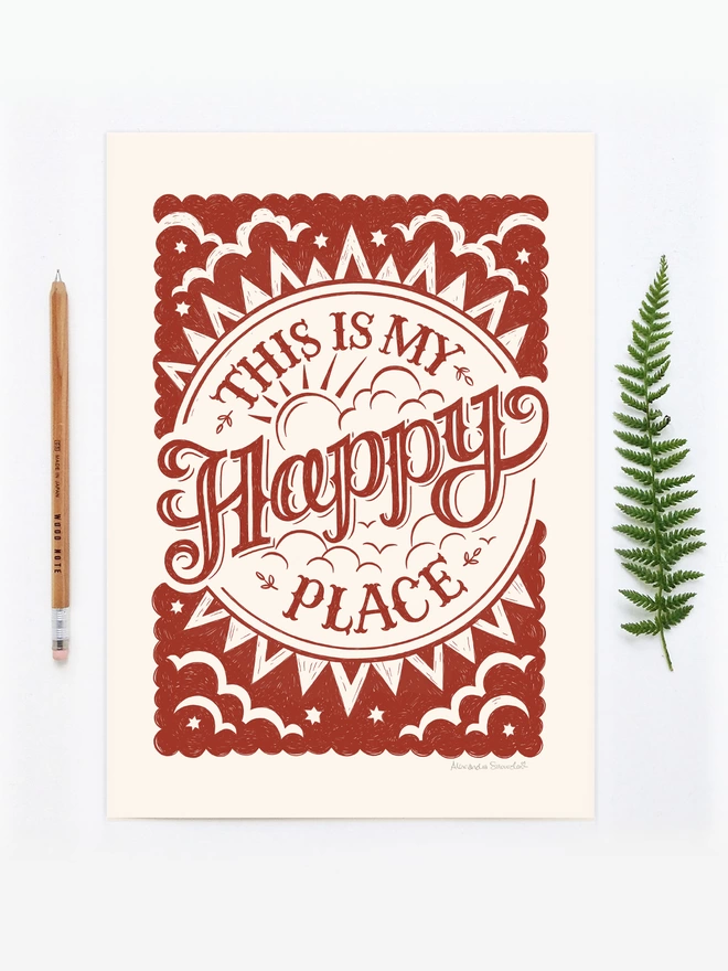 red typographic happy place print unframed with fern and pencil