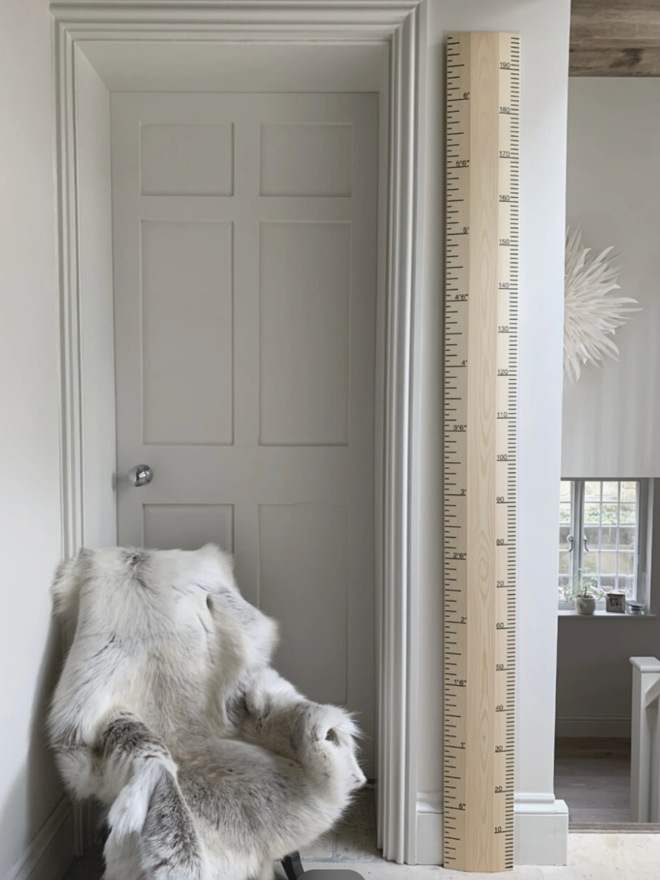 Raw Redwood Ruler Height Chart. A wooden height chart leaning on a child’s wall.