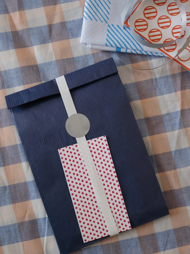A Mr.PS Checkerboard hankie with optional gift wrapping; navy paper, white ribbon and patterned gift card