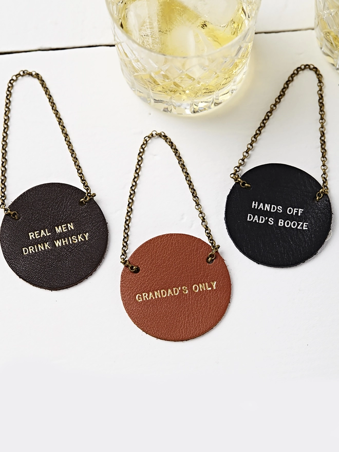 group shot of bottle tags. Brown, tan and black with gold lettering.