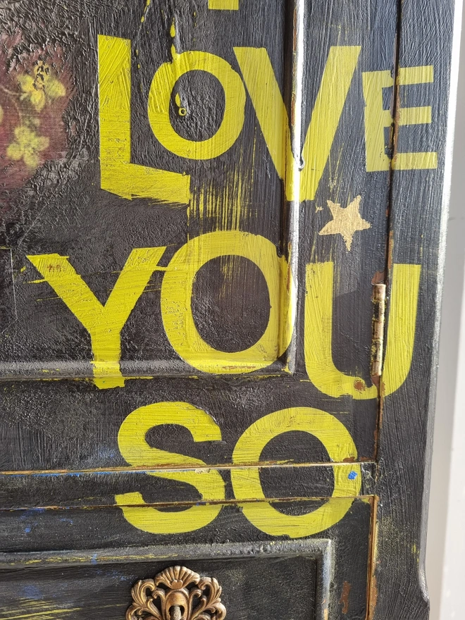 Elegant cocktail cabinet in black with colourful florals and text in chartreuse green that reads 'hot tramp, I love you so', a David Bowie lyric. Heavily distressed to age it. The interior is cobalt blue.