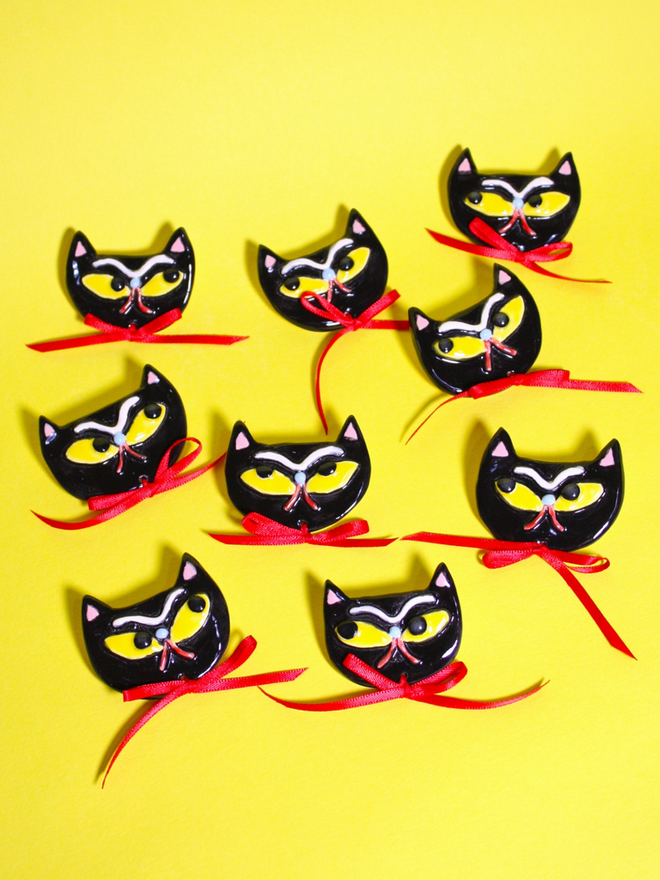 Spooky grumpy Black Cat Brooch with yellow eyes and red satin ribbon.