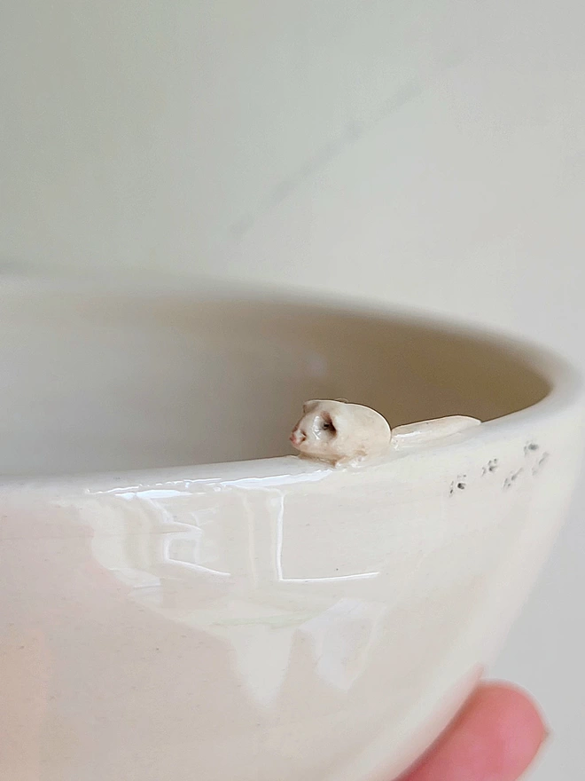 ivory cat bowl showing closeup of tiny handmade mouse attached to the  rim with tiny paw printsrim with paw prints etched on the 