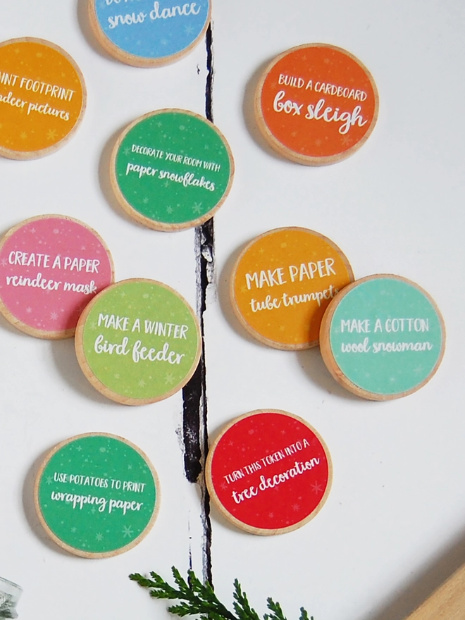 Several wooden tokens with brightly coloured labels lay on a white surface.
