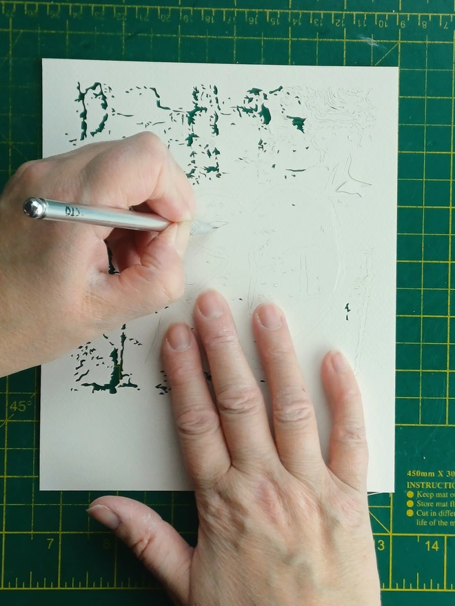 Rosie cutting detail in her carved initials papercut