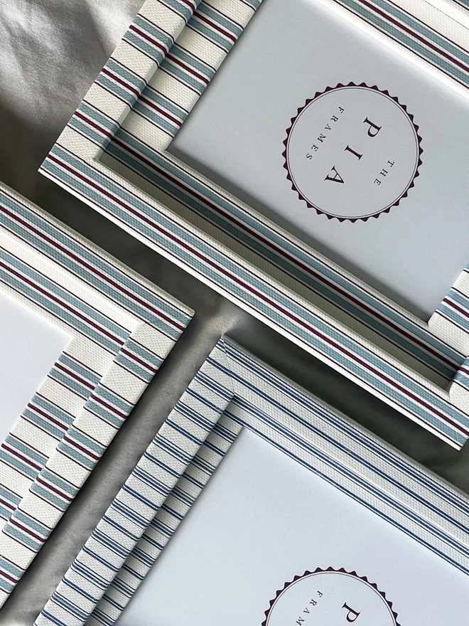 Sky & Scarlet Tailor Stripe Frame, a patterned colourful frame sitting on a plain white surface. It is joined by multiple frames. 