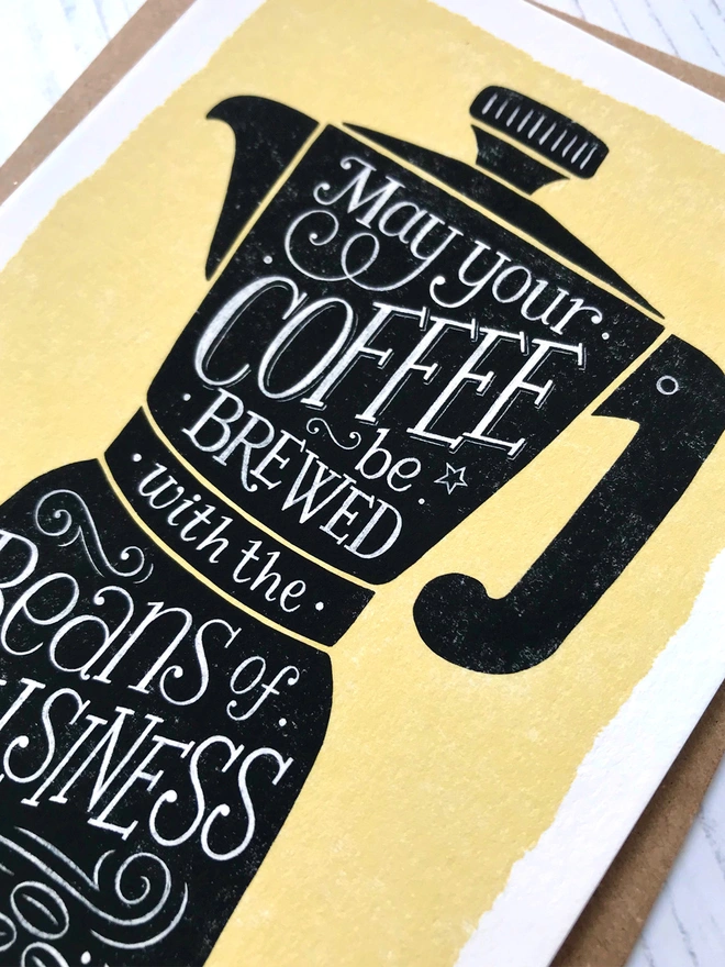 black coffee cup on yellow background with white hand lettered coffee quote inside detail close up