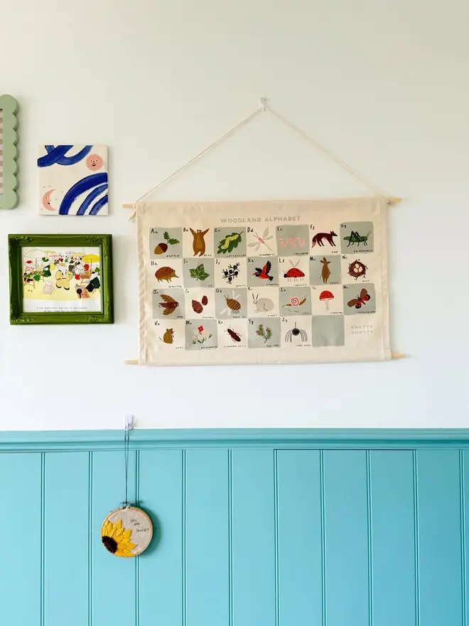 Woodland Alphabet Fabric Banner, hanging on a white wall. 