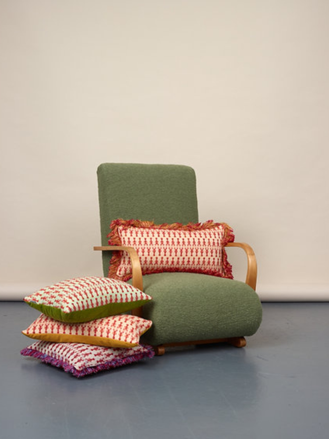 lobster tassled rectangular cushion. a rectangular cushion embroidered with red lobsters photographed on a green chair.