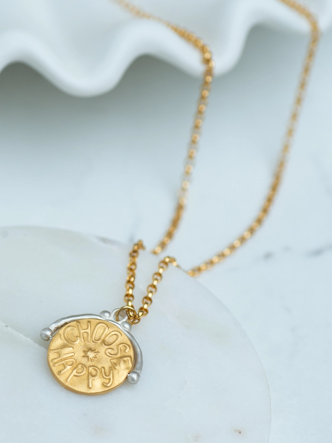 A beautiful blend of function and feeling, this spinner necklace features a star-eyed smiley and “choose happy” engraving on a two-tone pendant. Crafted in sterling silver and gold plate, it’s a thoughtful fidget necklace for anxious hands — a meaningful gift or personal keepsake designed to bring comfort and positivity.