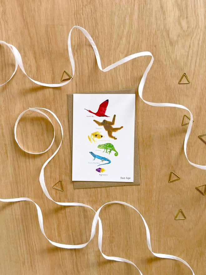 a greetings card featuring illustrations of animals in colours making up the rainbow with the text “have hope”