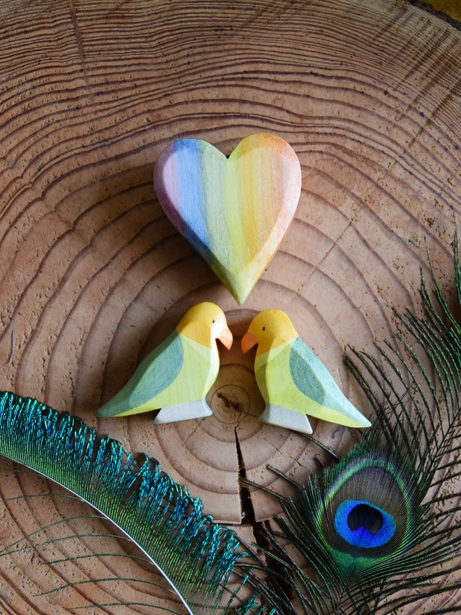 wooden toy lovebird on flatlay with rainbow heart