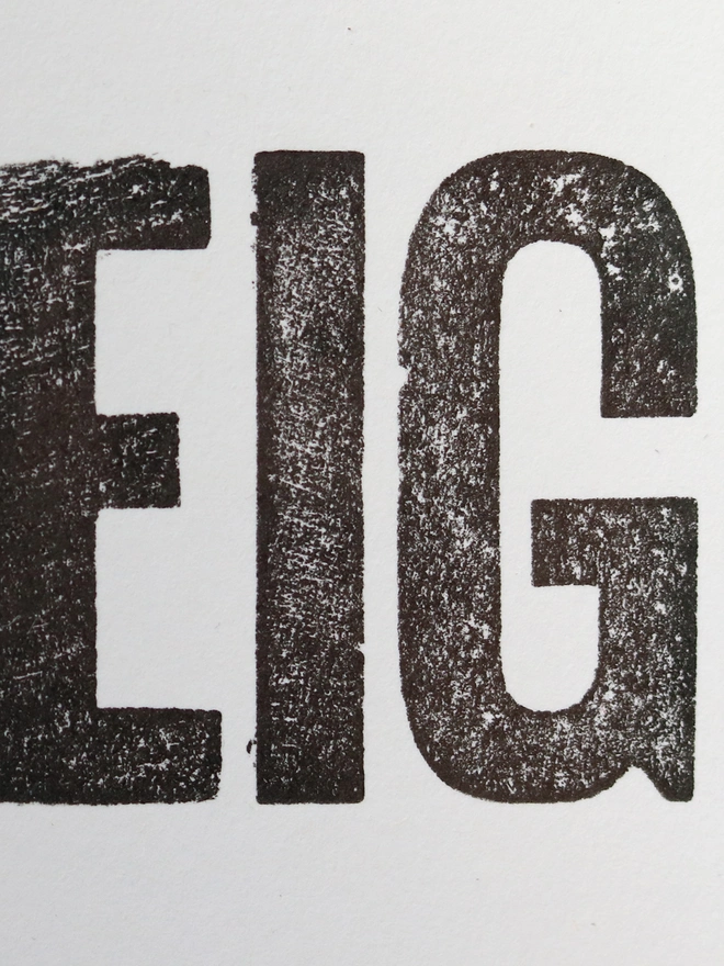 Original letterpress poster featuring the words 'love your neighbour, welcome the stranger' printed in black ink on white paper