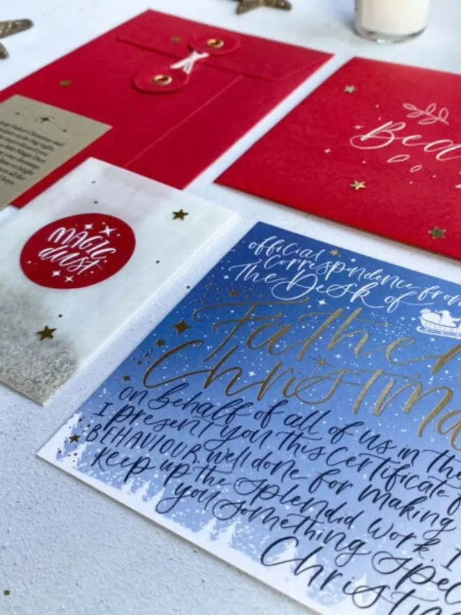 A close-up of navy and gold calligraphy on the blue certificate, with red envelopes behind it.