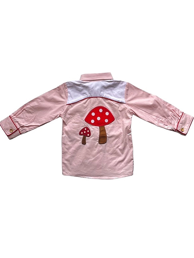 The back of a pink and white cowgirl shirt showing two applique toadstools