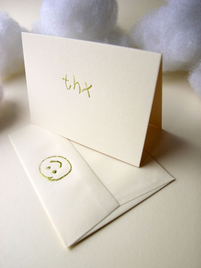 sandy coloured card with thx short for 'thank you' hand foiled in kids hand writing