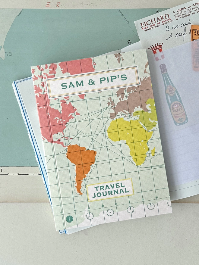 World map travel journal lifestyle shot on open book